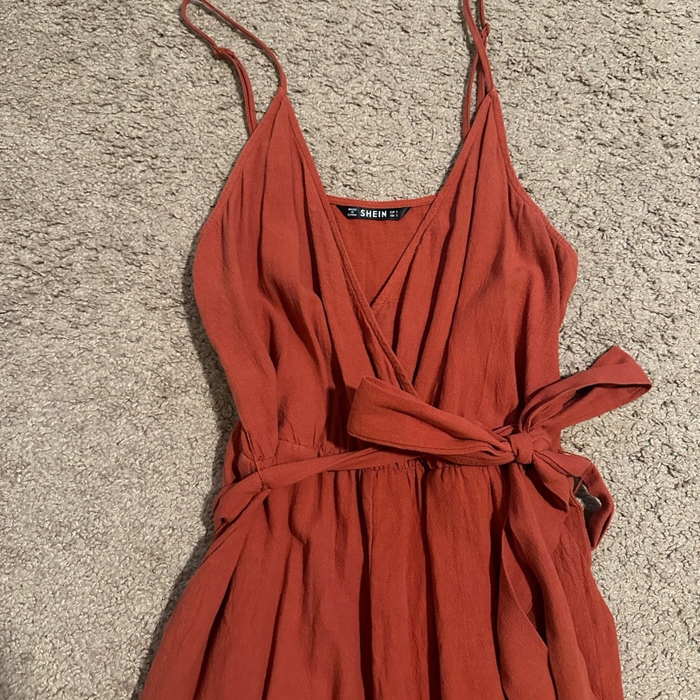 V-neck Jumpsuit with spaghetti straps. Bows on waist and ankles